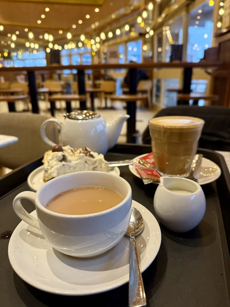 Tea, coffee and a slice of cake served on a tray